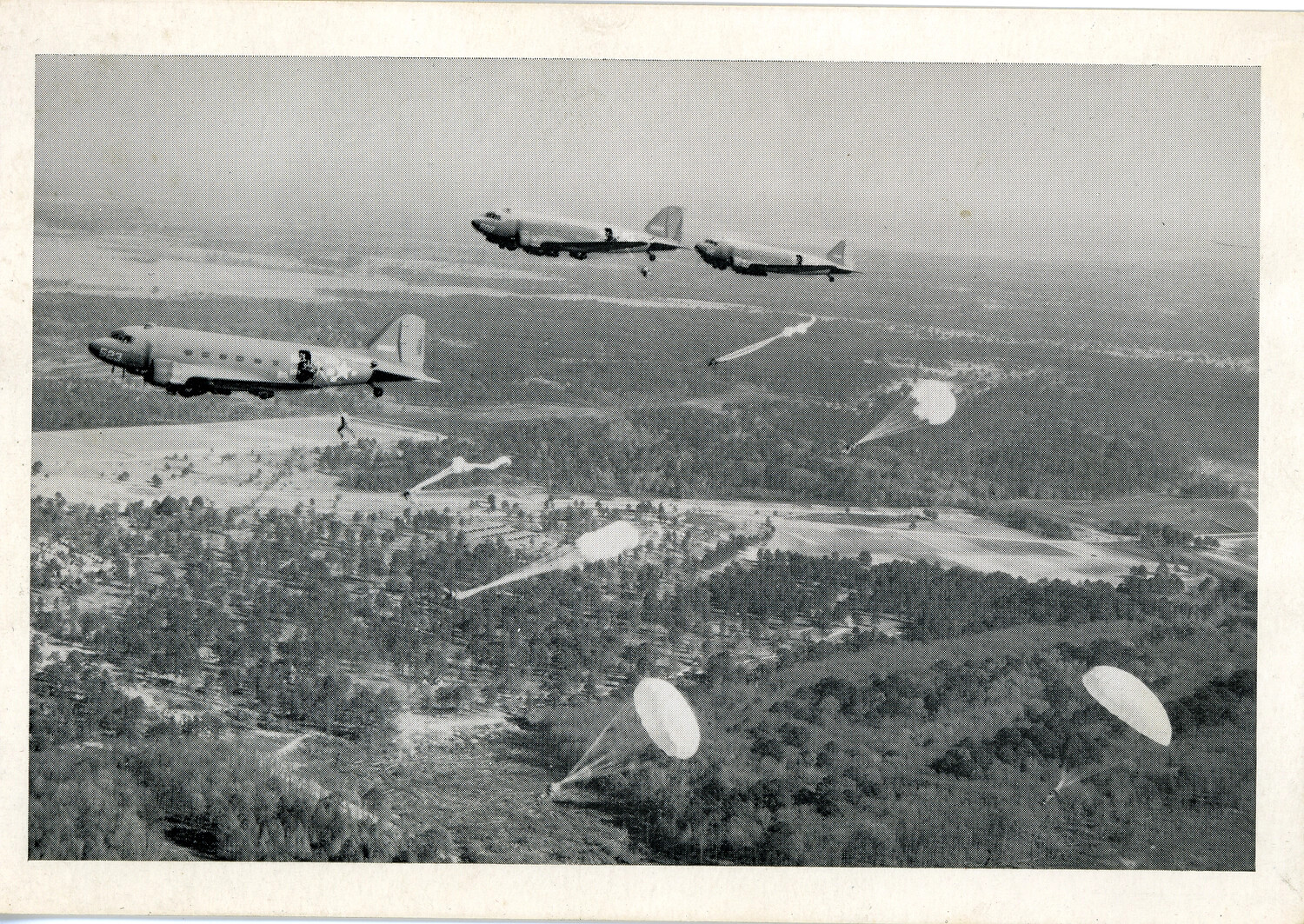 C-47 Transport Aircraft Dropping Paratroopers Over European Terrain, WWII Airborne Operation