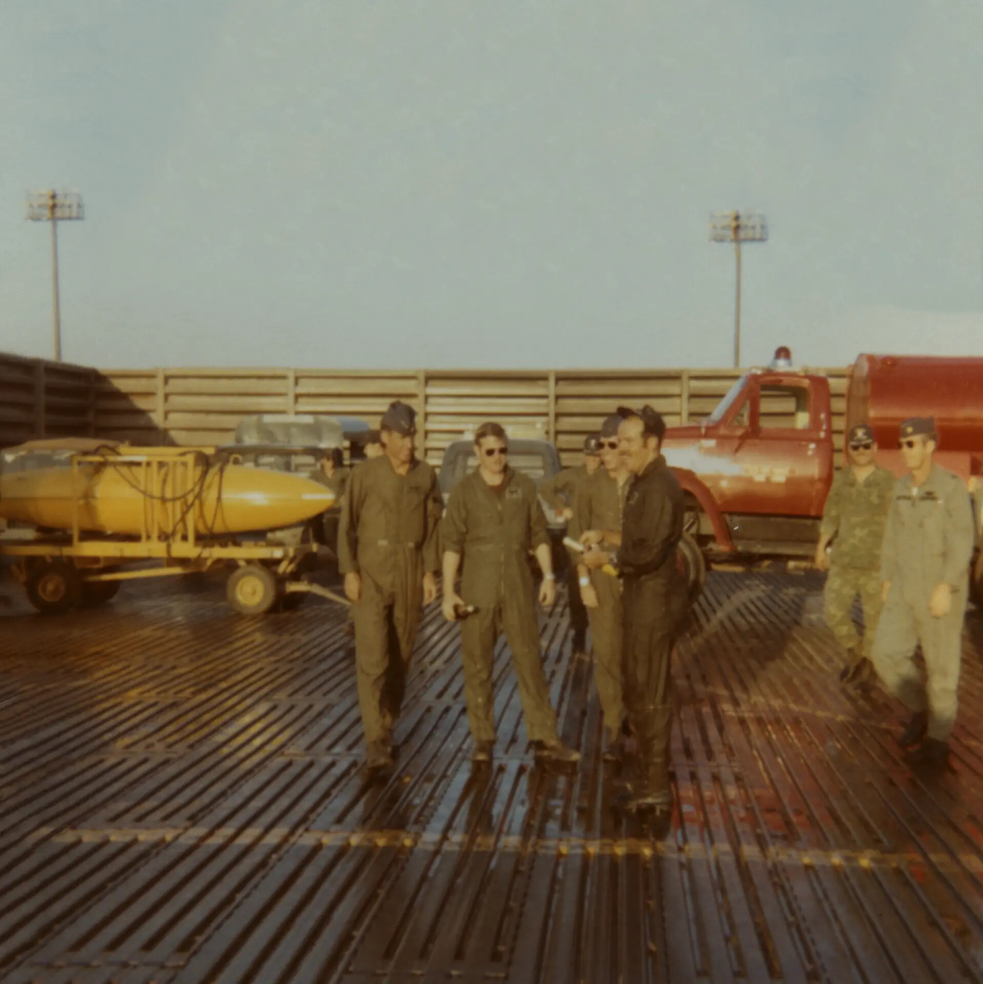 Flight Crew Personnel on PSP Ramp with Ordnance Trolley and Crash Truck, Vietnam War Era Airfield