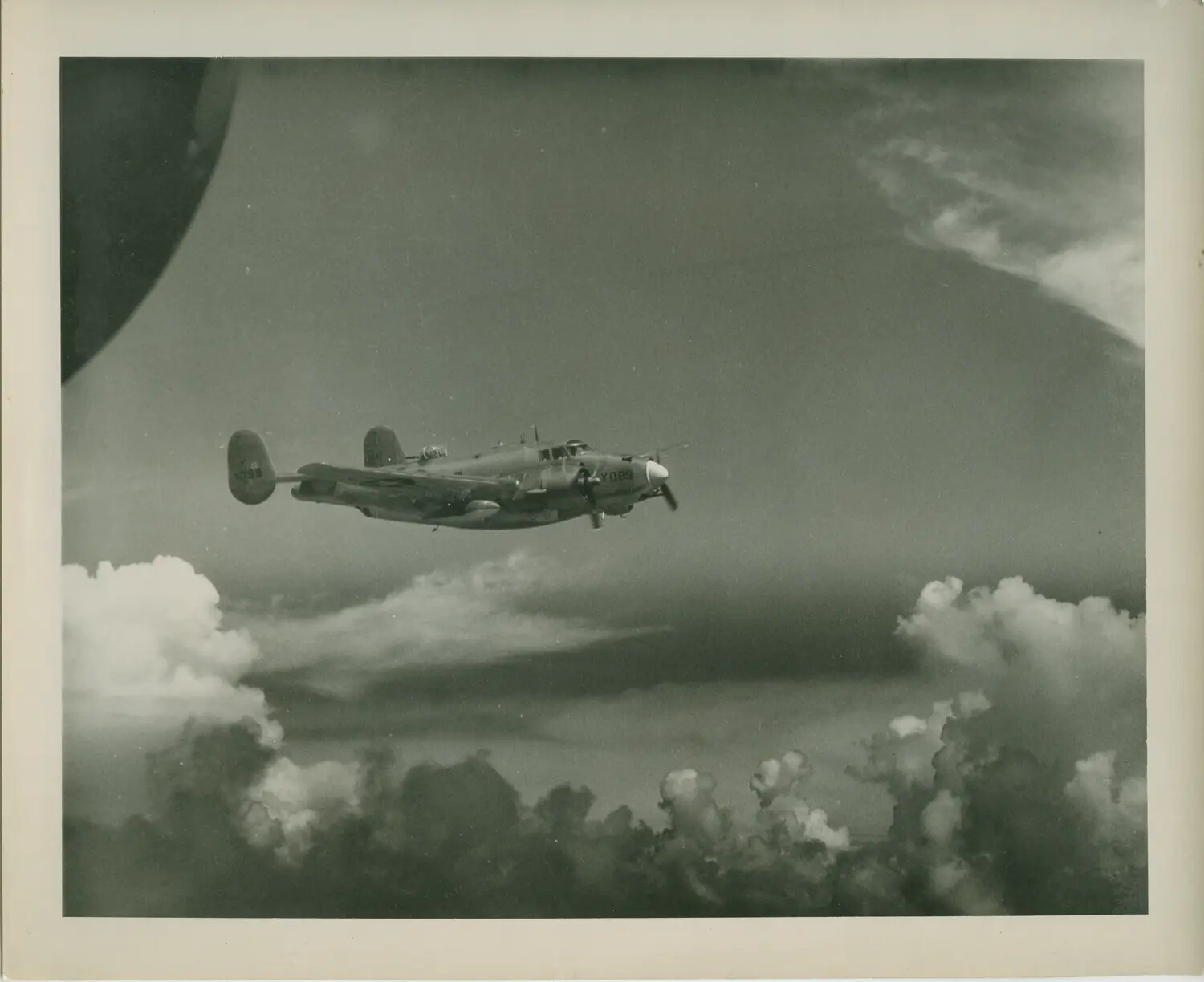 U.S. Navy Twin-Engine Patrol Aircraft in Flight Above Clouds, USS Petrof Bay (CVE-80) Collection
