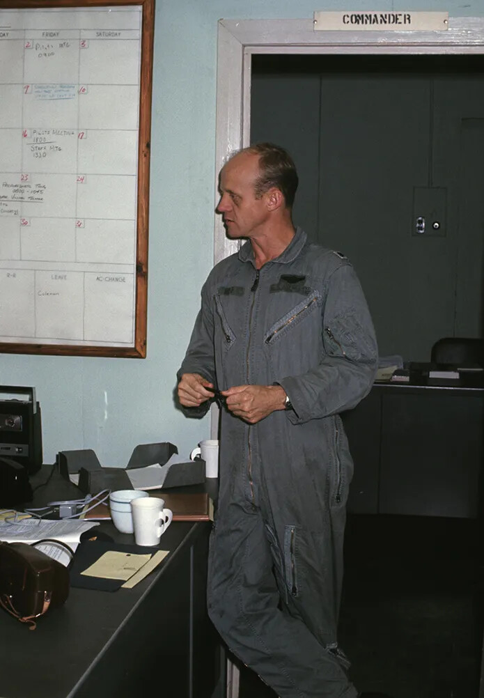Airman in Sage Nomex Flight Suit Outside a Squadron Commander's Office, with Handwritten Scheduling Board — Vietnam-Era Colour Photograph, Banner Project Working Variant
