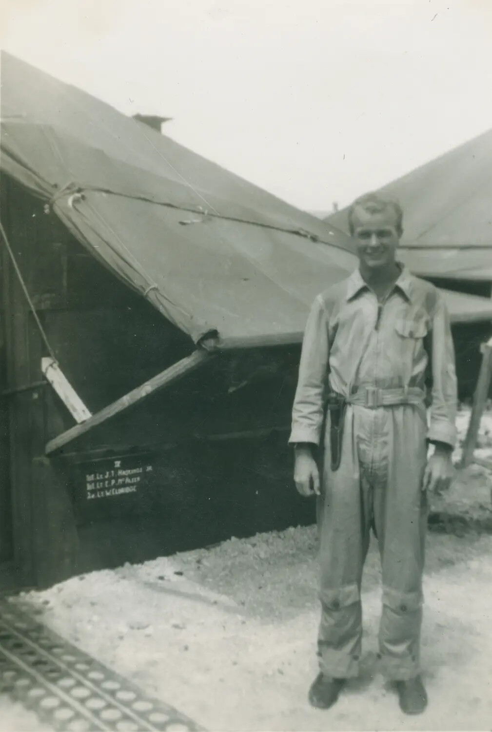 Officer in Flight Coveralls Outside Squadron Tent Quarters, McAleer Album