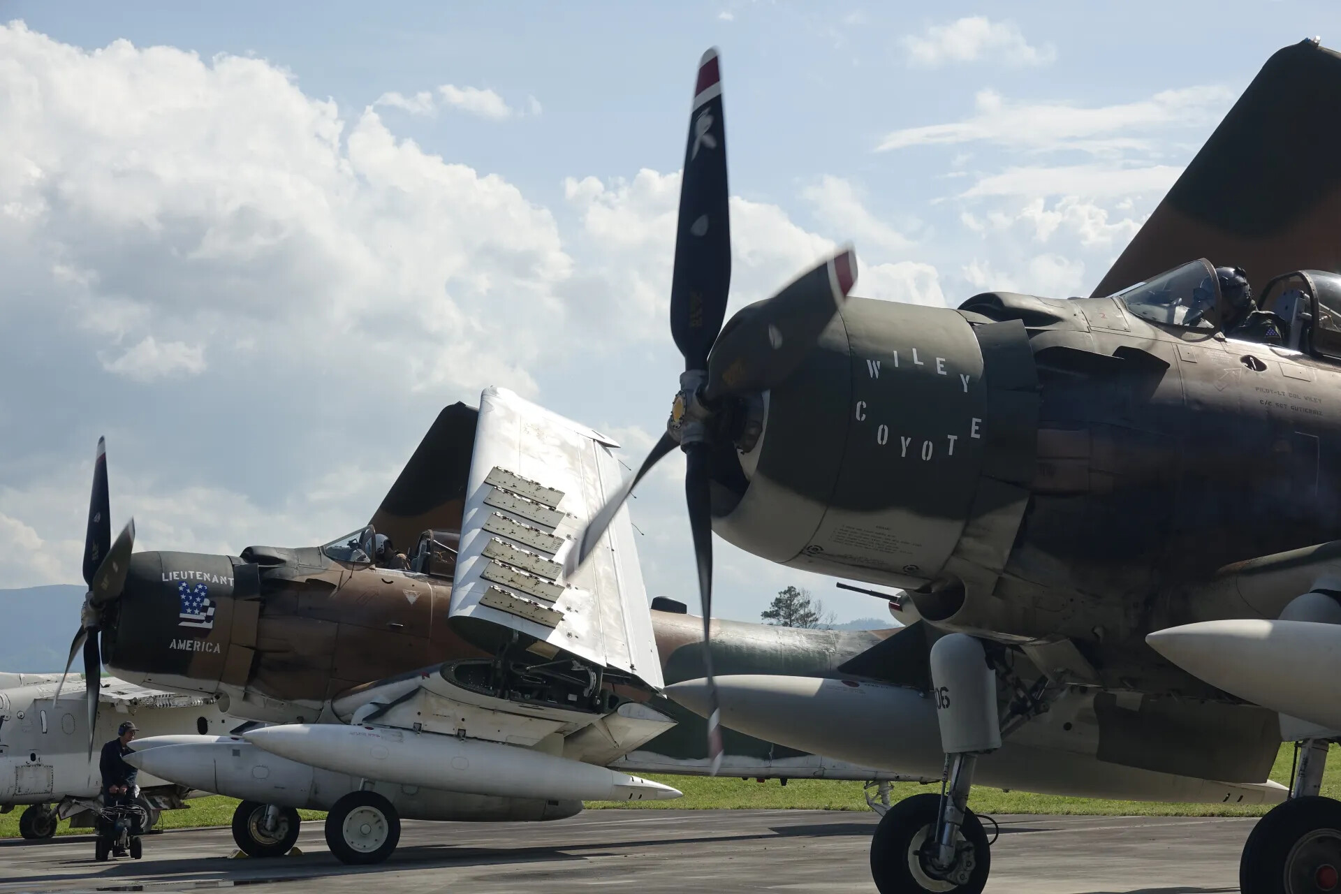 Two A-1 Skyraiders 'Wiley Coyote' and 'Lieutenant America' on Flight Line, Engines Running