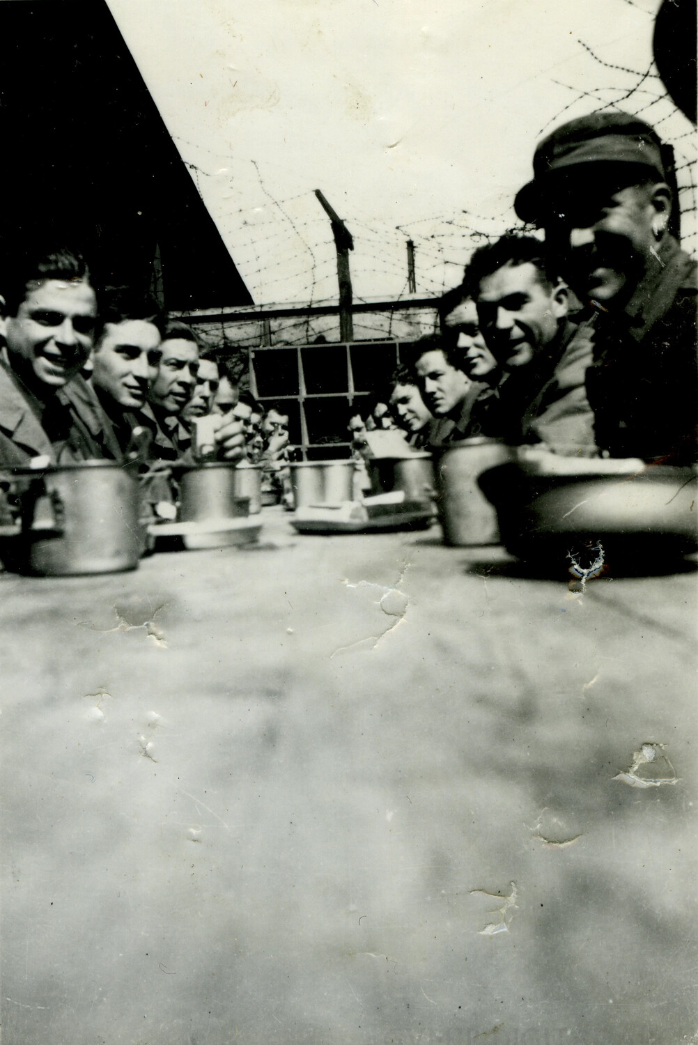 American Soldiers Sharing a Meal at Outdoor Mess Table Behind Barbed Wire Fence, WWII