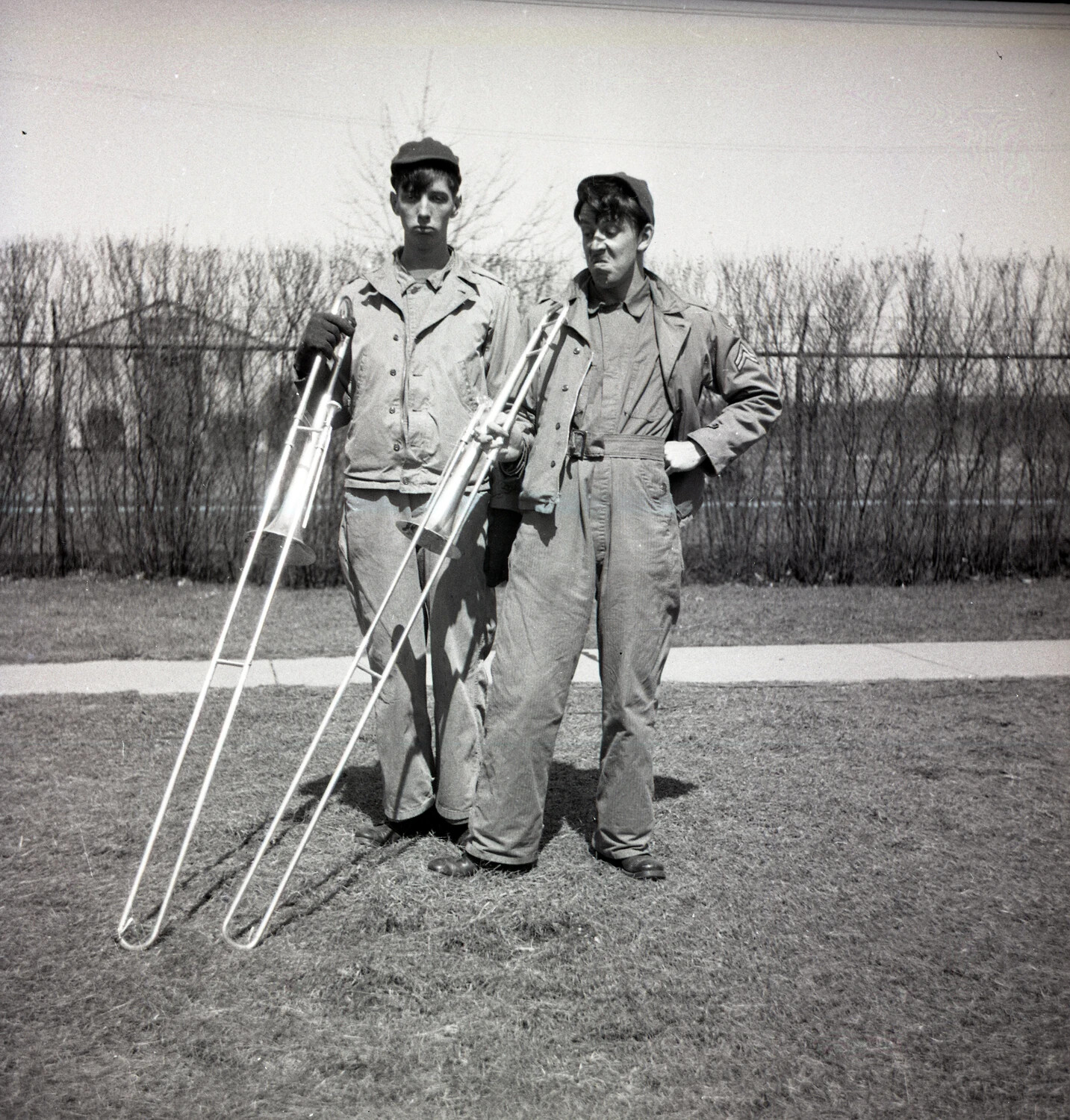 Two Military Bandsmen Posing with Trombones, Outdoor Base Grounds