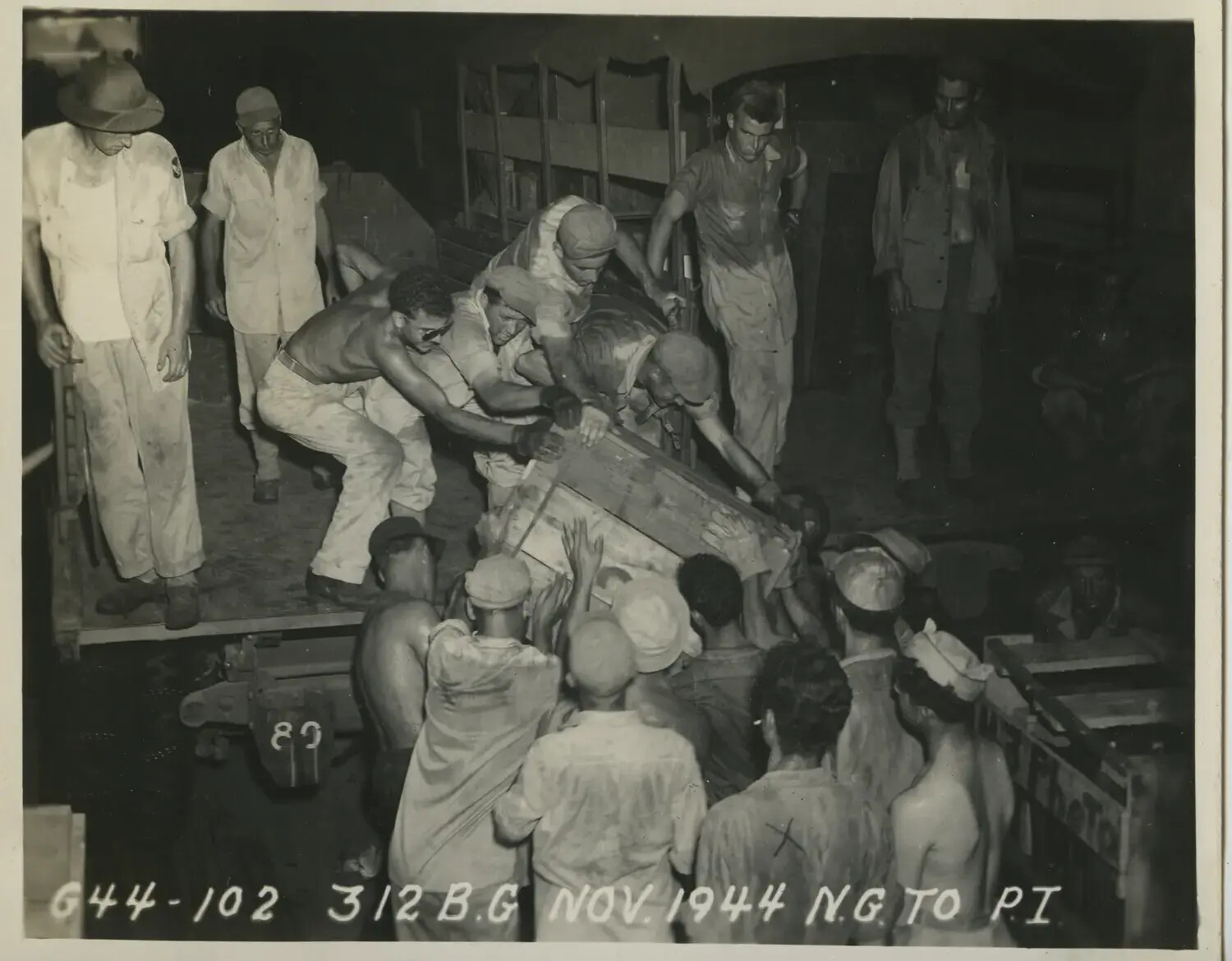 Servicemen Loading Heavy Crate onto Truck at Night, 312th Bombardment Group, November 1944
