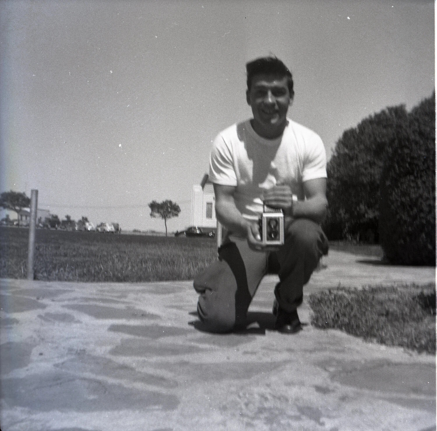 Man Kneeling with Twin-Lens Reflex Camera, Outdoor Portrait, 1950s
