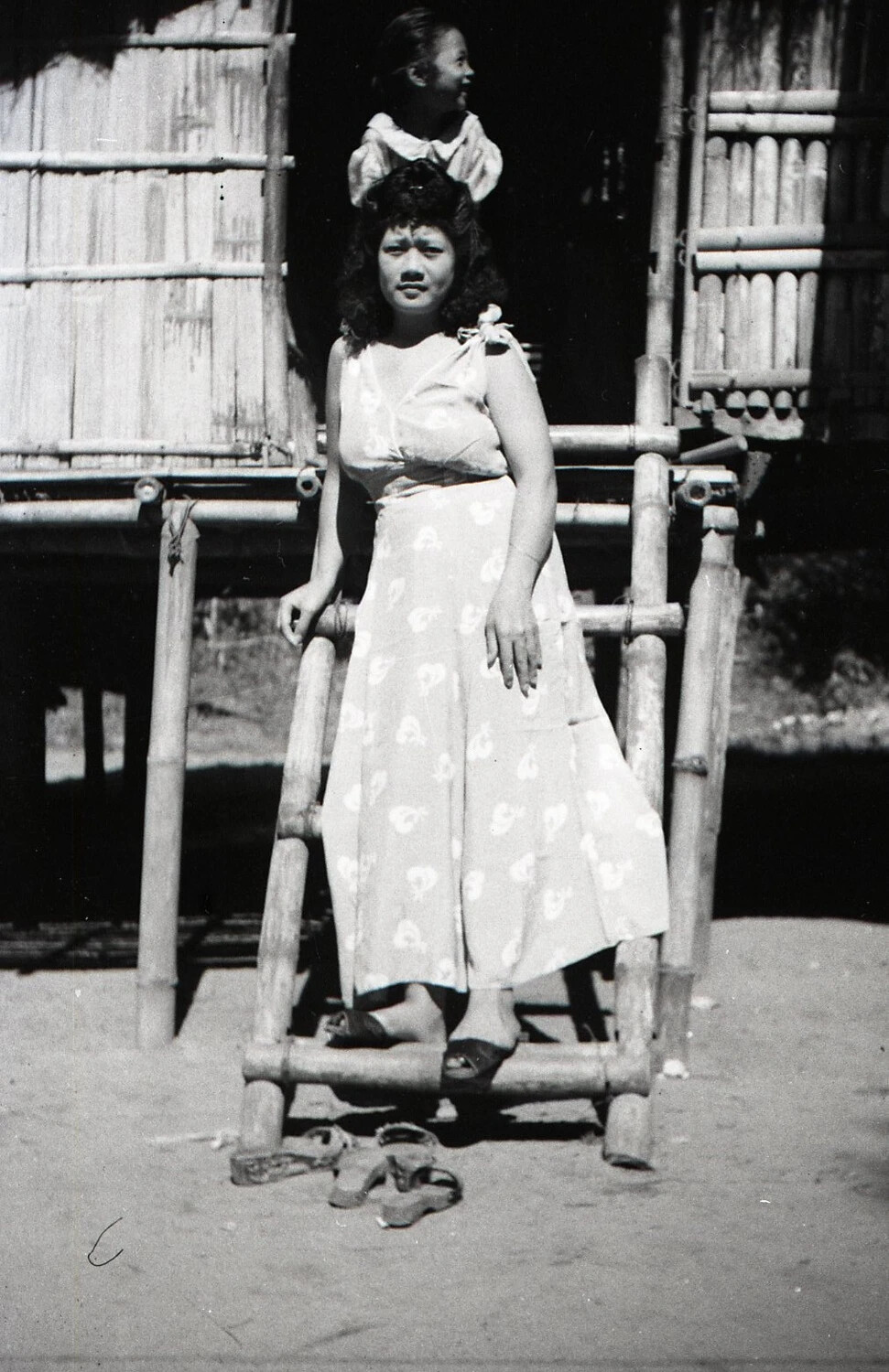 Young Filipino Woman on Bamboo Ladder with Child in Doorway, Luzon, Philippines, WWII Era