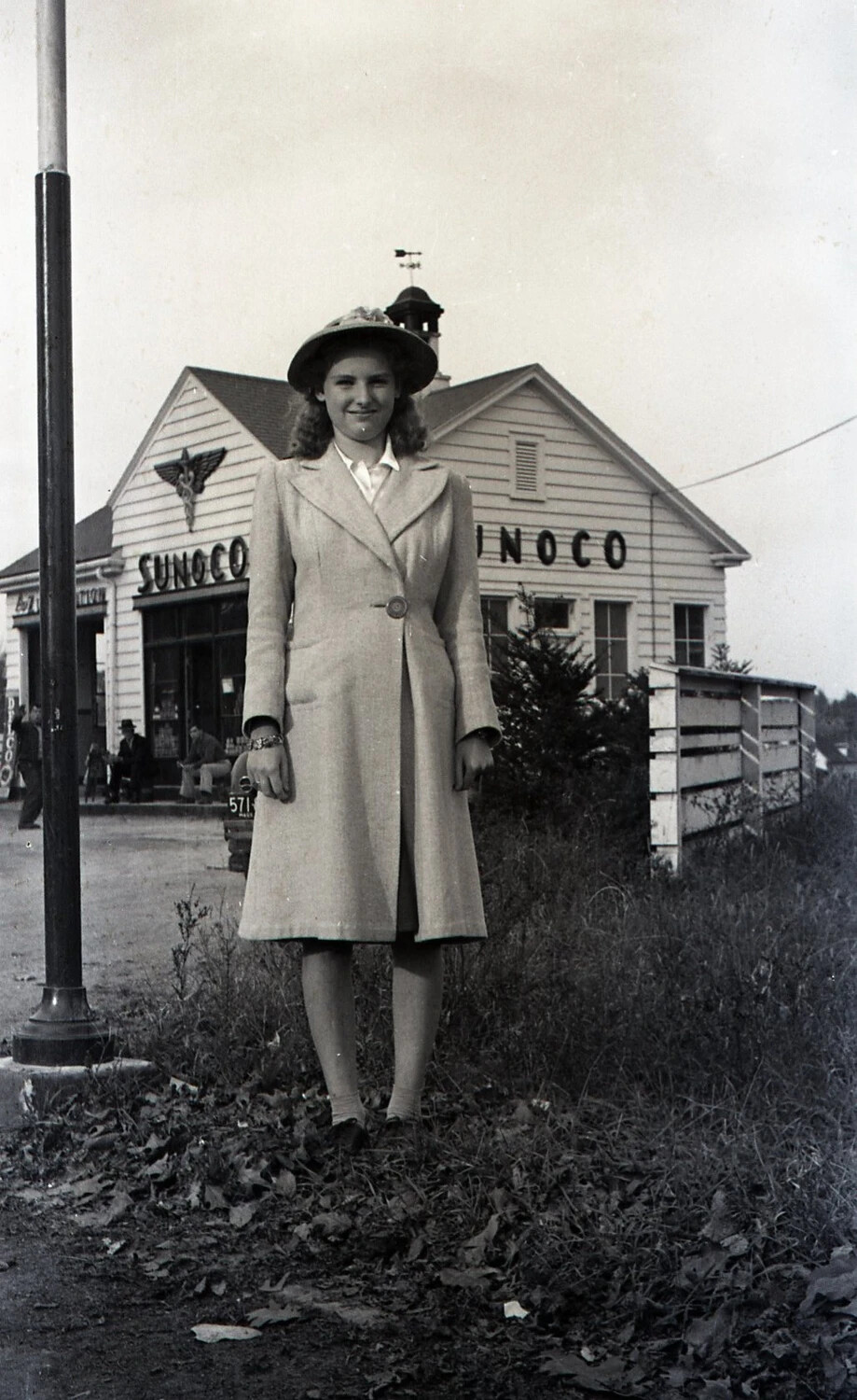 Young Woman in Coat and Hat at Sunoco Station, New Hampshire, WWII Era