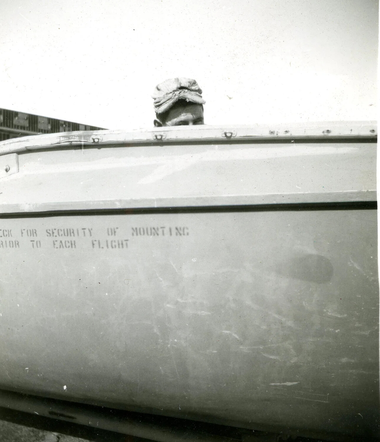 Airman Peering Over External Aircraft Fuel Tank with Stenciled Maintenance Instructions, Keesler Field, 1946