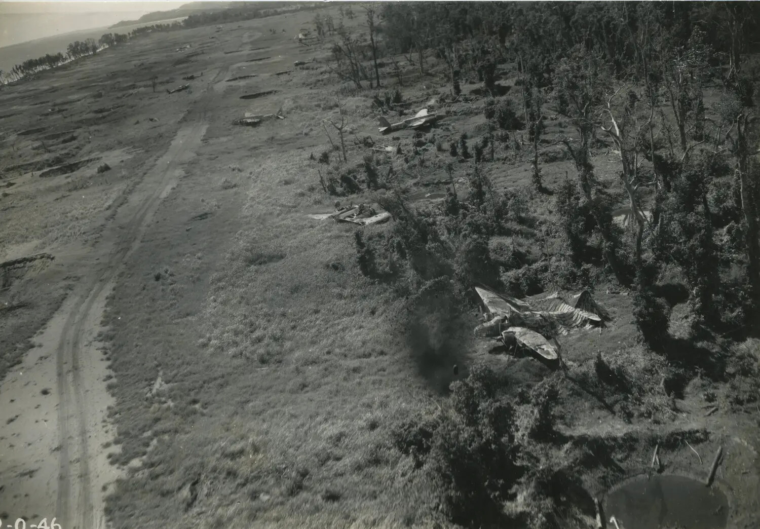 Aerial View of Wrecked Japanese Aircraft Along Airfield Tree Line, New Guinea, World War II Era
