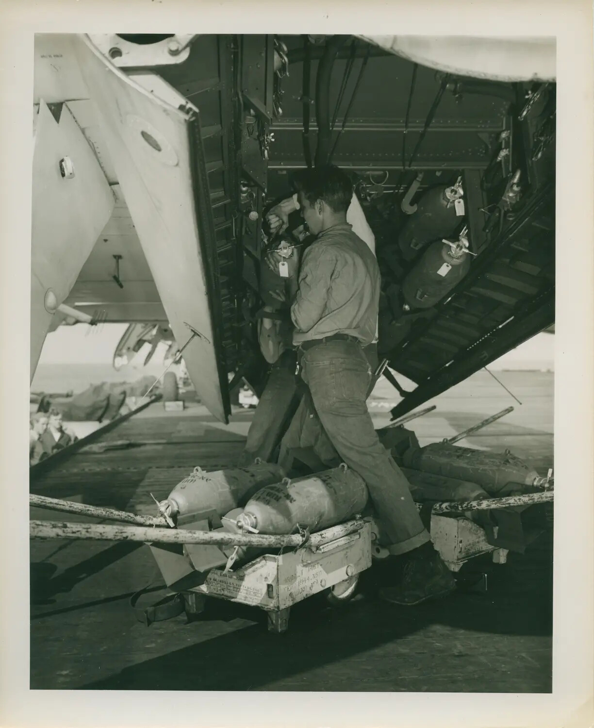 Ordnance Loading Beneath a Carrier Aircraft Bomb Bay, USS Petrof Bay (CVE-80), WWII
