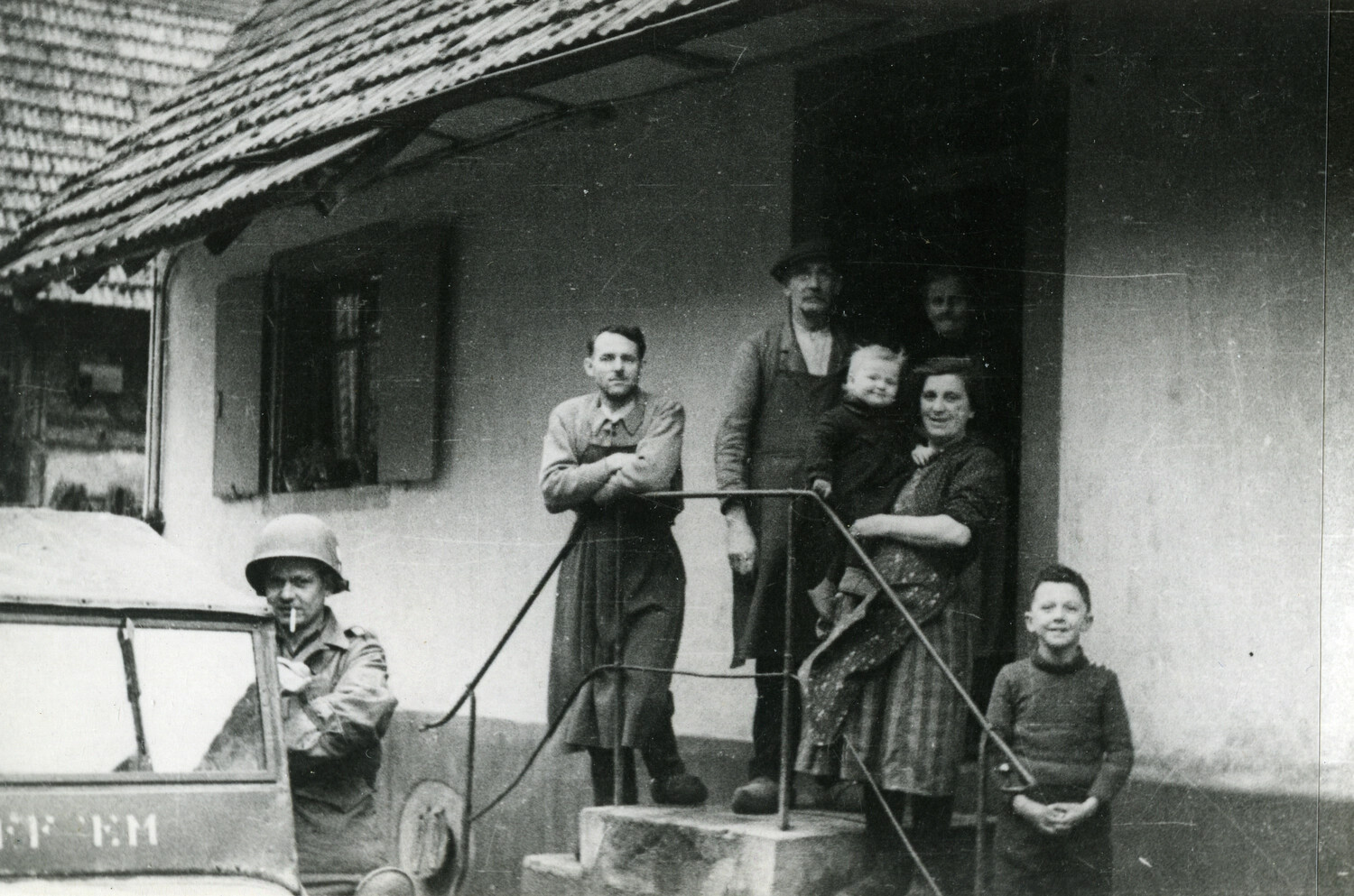 U.S. Paratrooper and a German Civilian Family Outside a Farmhouse, Postwar Occupation