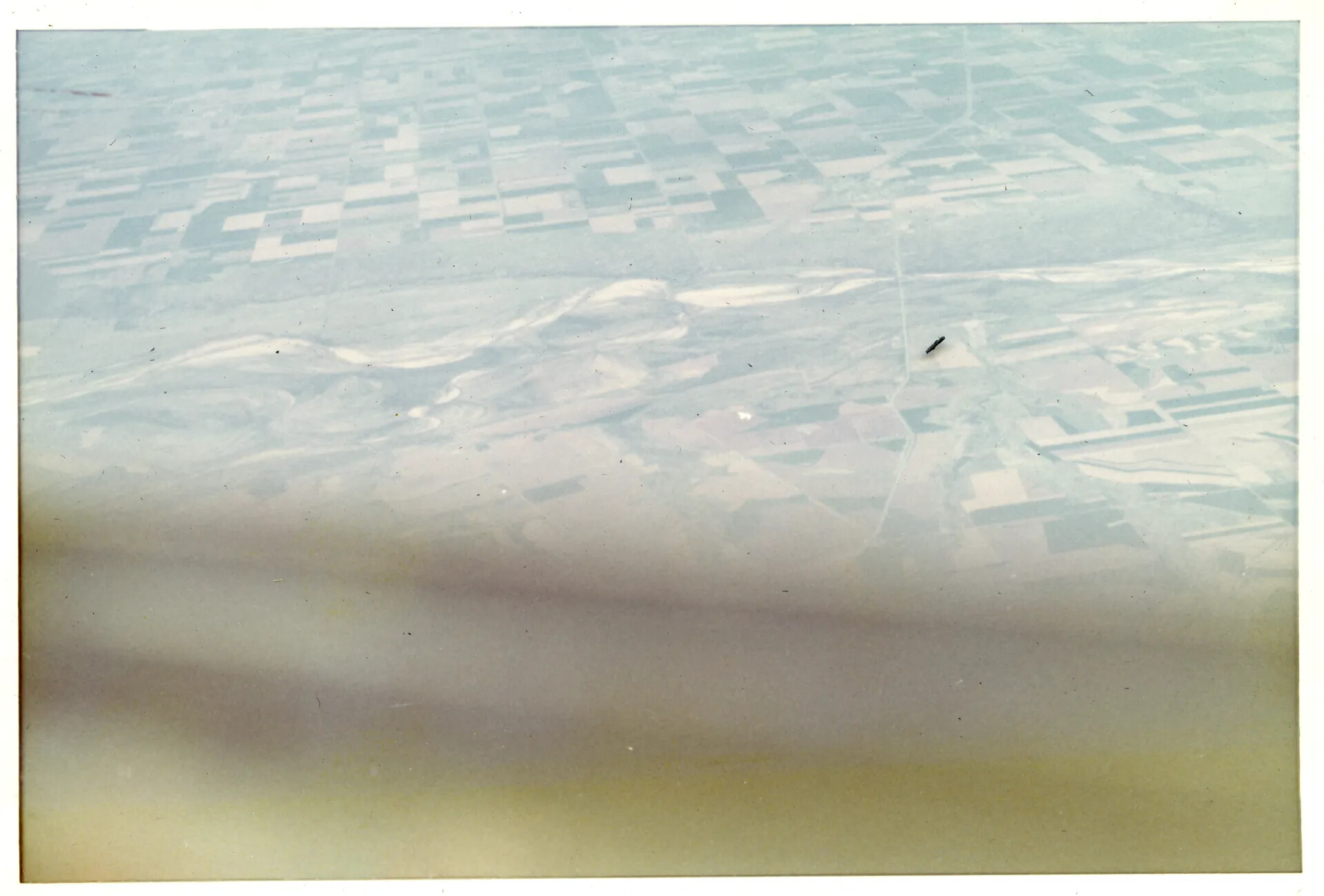 Faded Aerial Photograph of Agricultural Terrain with Distant Aircraft, Vietnam War Era (Doug Carmichael Collection)