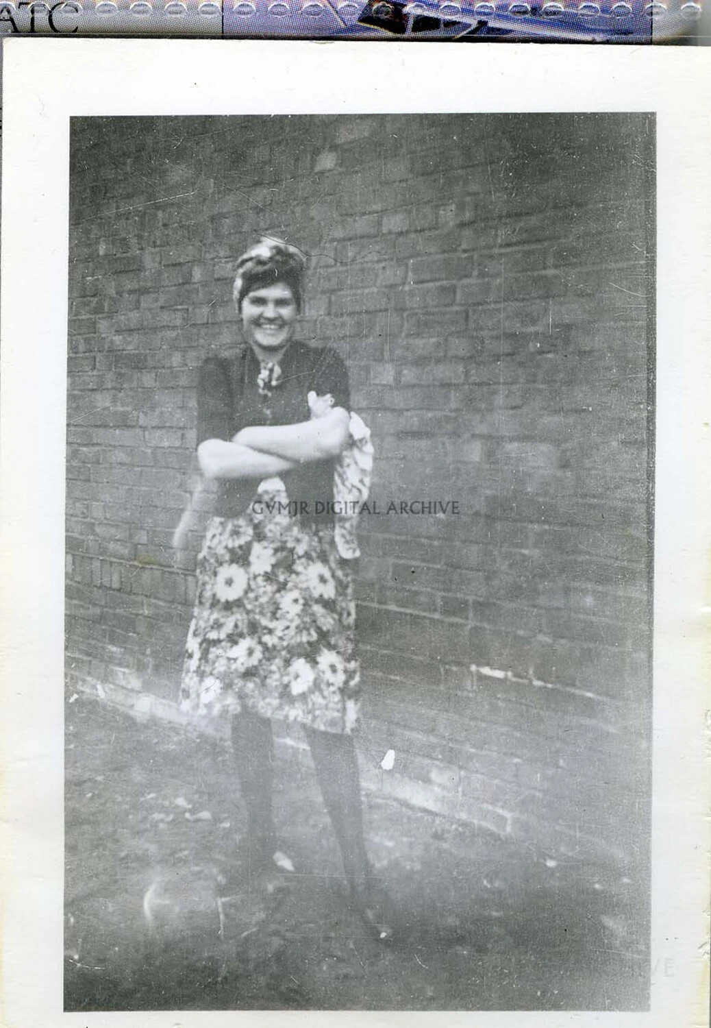 Woman in Floral Skirt Posing Against a Brick Wall, Europe, circa 1944-1945