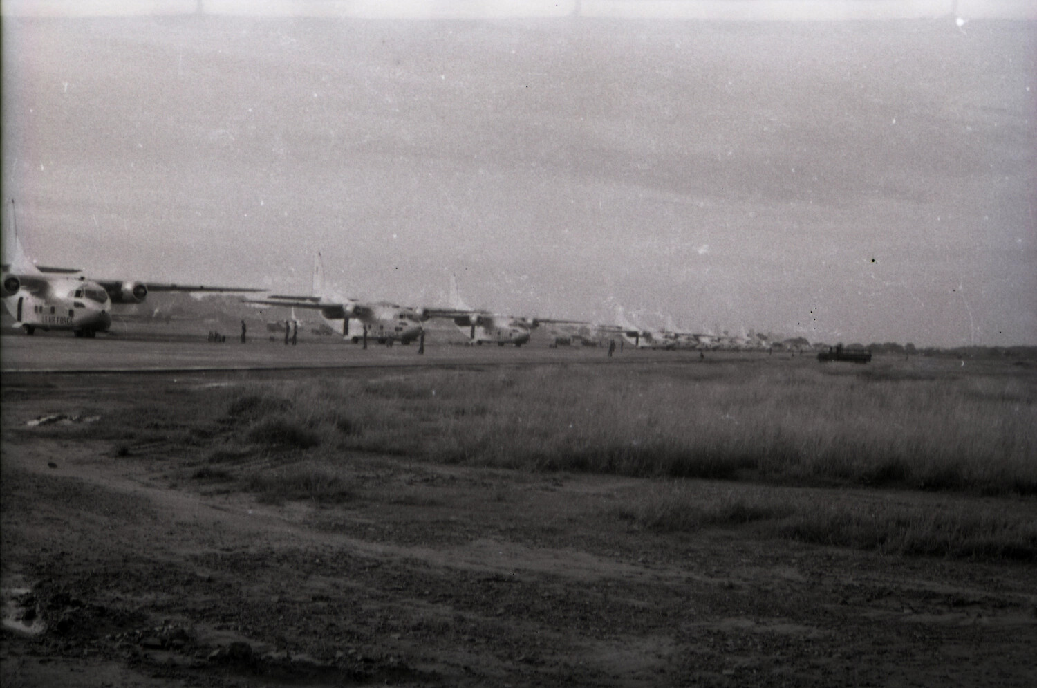 Line of Fairchild C-119 Flying Boxcars on the Runway with Military Truck