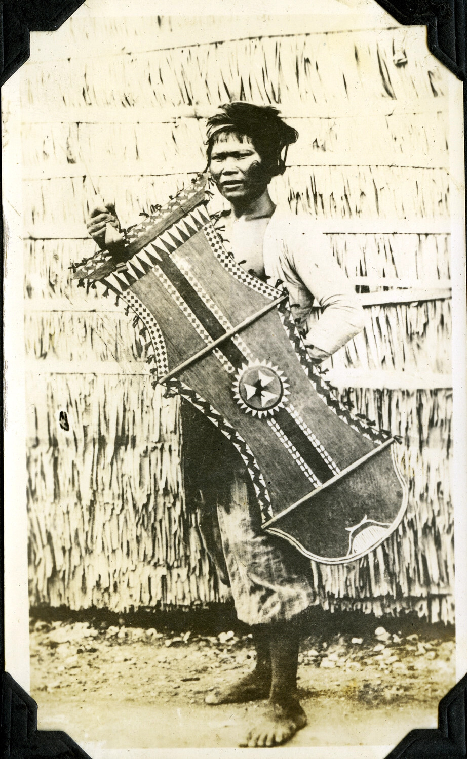 Man Displaying a Traditional Carved and Painted Shield, Philippines, Early 20th Century
