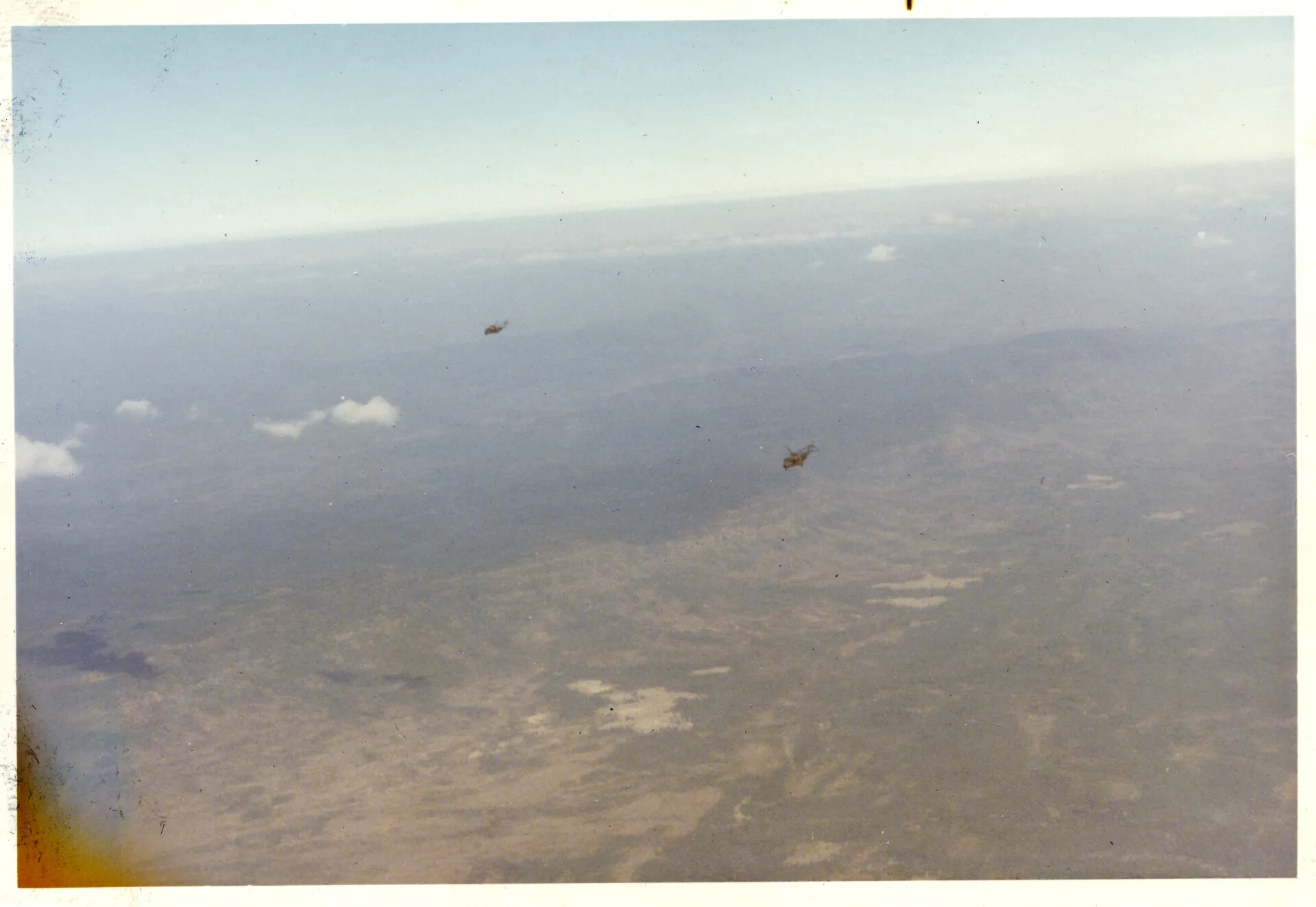 Two Helicopters in Flight Over Southeast Asian Terrain, Nakhon Phanom Area, Vietnam War Era