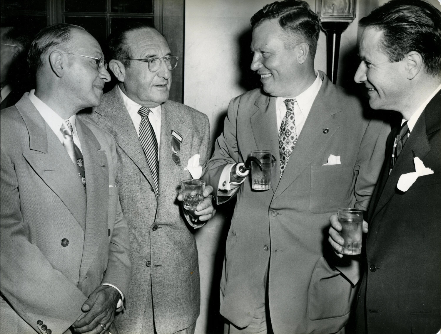 Convention Attendee with Hook Prosthetic Holds Drink at DAV Reception, Late 1940s