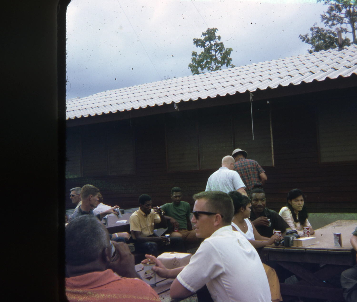 Servicemen and Guests Socializing with Falstaff Beer at Base Camp Picnic Tables, Vietnam War Era (35mm Slide)