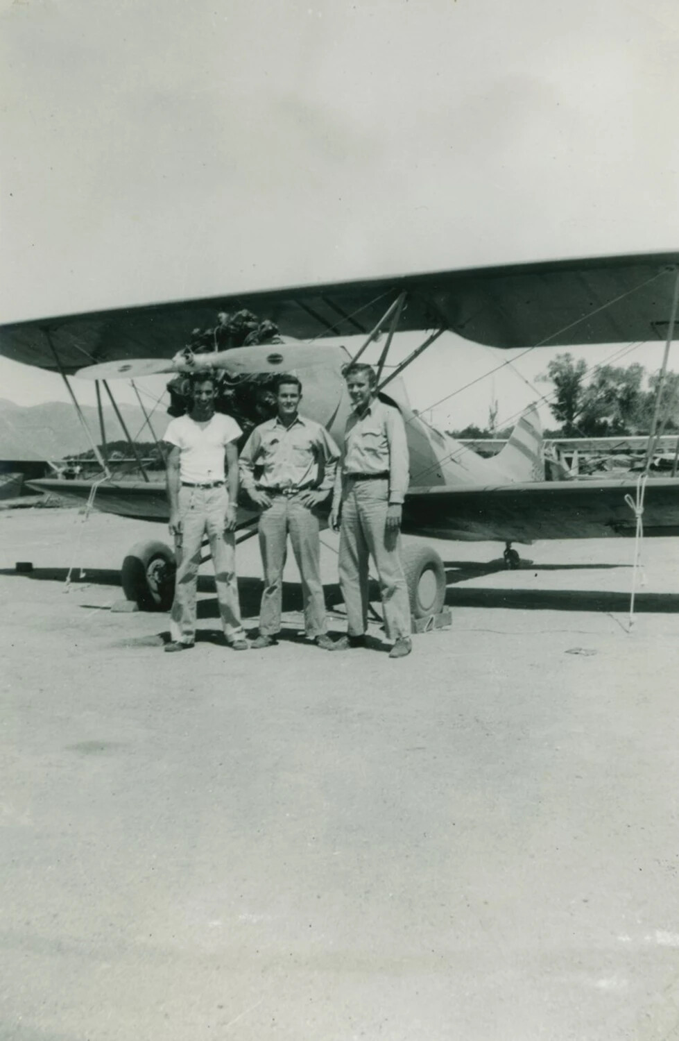 Three Men with Biplane Primary Trainer at Desert Airfield, WWII Era