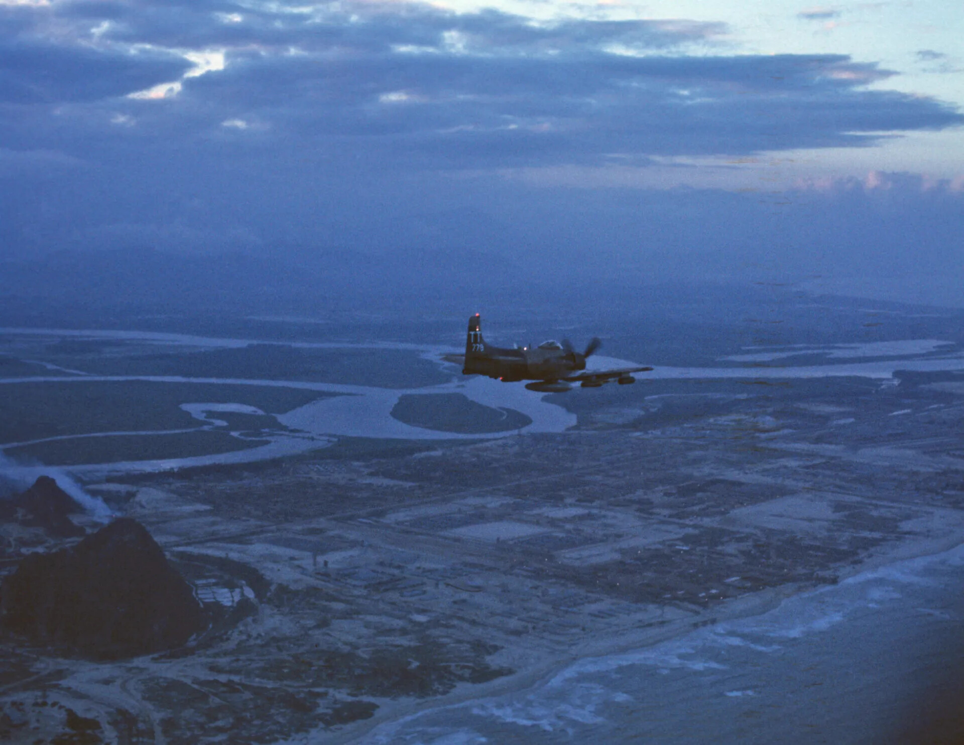 A-1 Skyraider in Flight Over Vietnamese Coastal Delta at Dusk