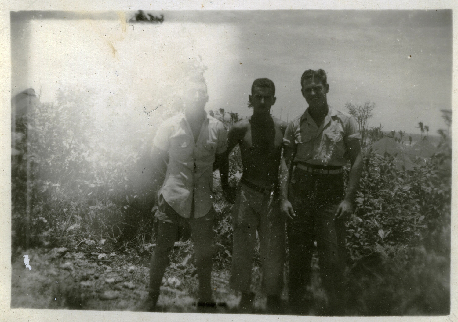 Three Servicemen on Hillside Overlooking Encampment, Pacific Theater, WWII