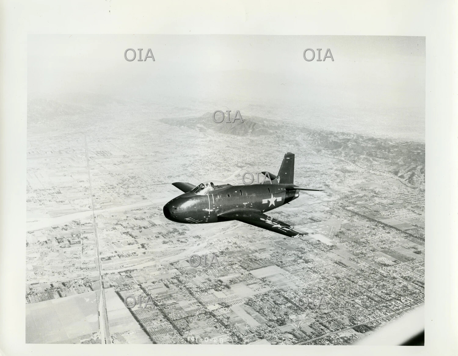 U.S. Navy Early Jet Fighter in Flight Over Urban Landscape, Late 1940s