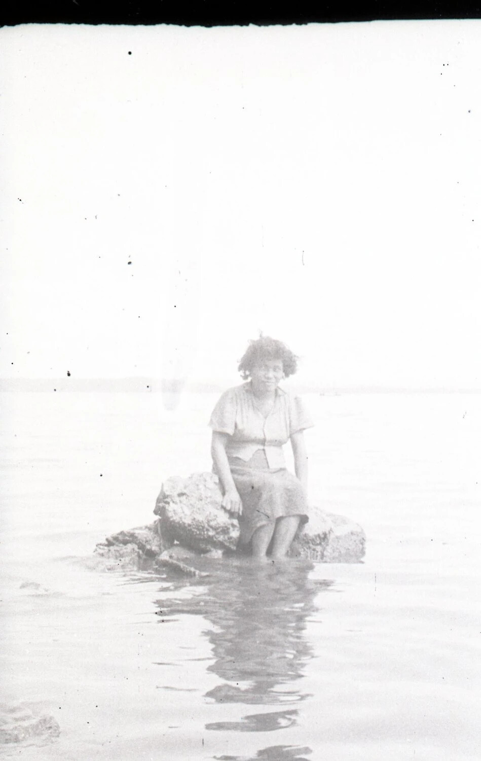 Woman Seated on Rock in Shallow Water, Philippines, WWII Era