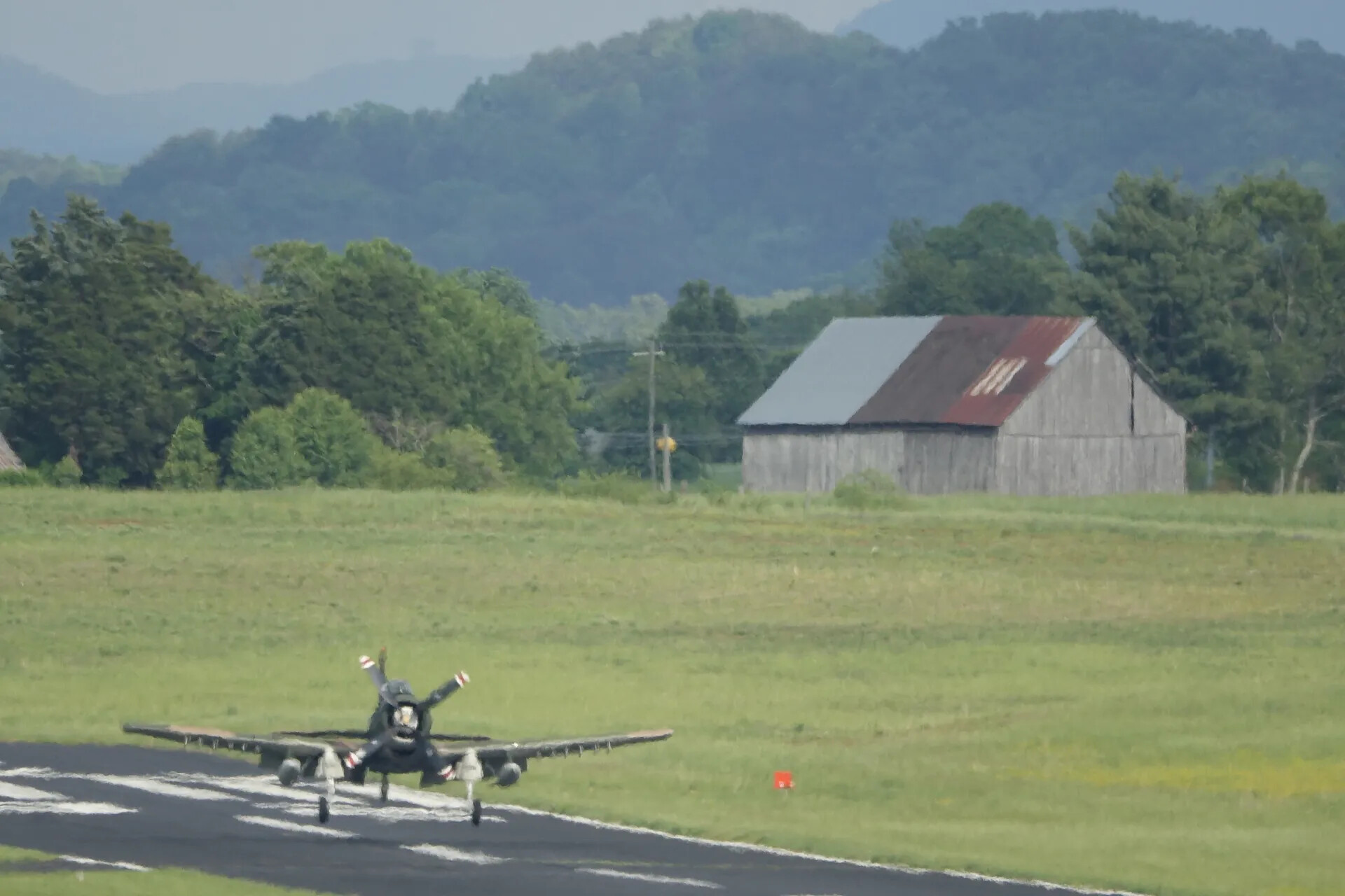Douglas A-1 Skyraider on Runway with Mountain Backdrop