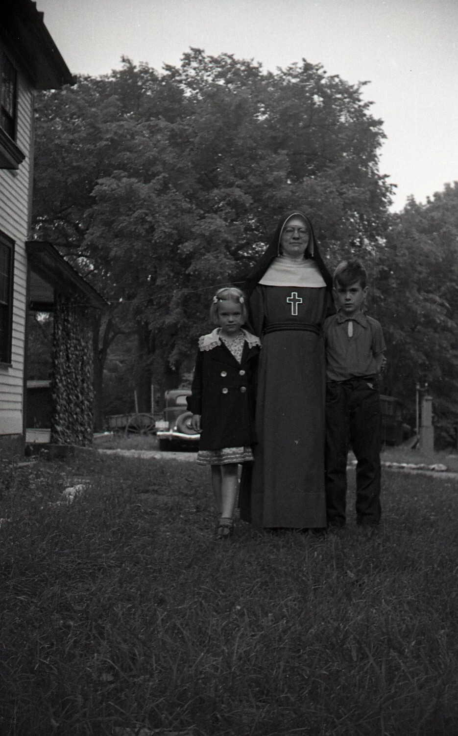 Nun in Habit with Two Children on Farmhouse Lawn, Mid-20th Century