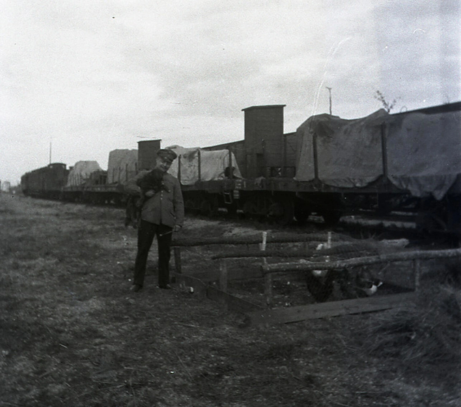 German Soldier with Small Animal Beside Military Supply Train and Improvised Coop, WWI