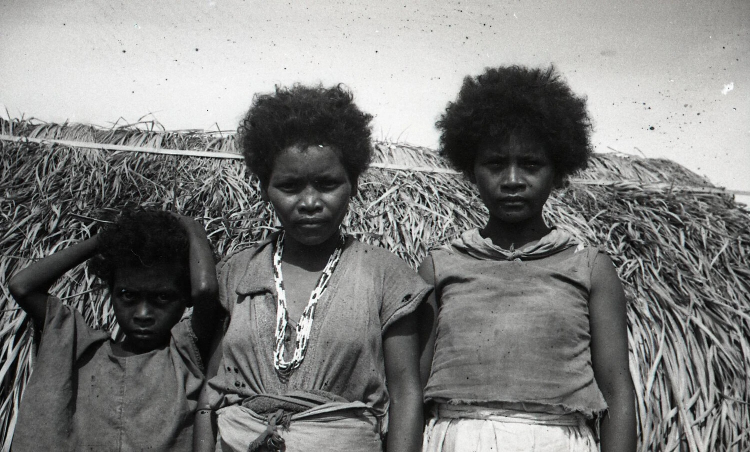 Aeta (Negrito) Family Portrait Outside a Thatched Nipa Hut, Luzon, Philippines, World War II Era