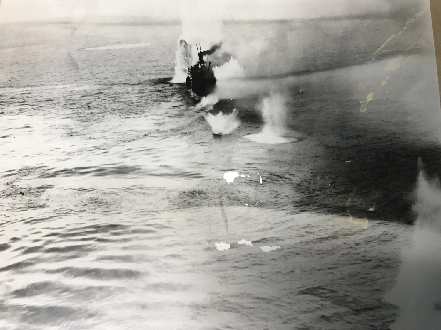 Bomb Splashes Bracket Japanese Vessel Near Coastline, Pacific Theater