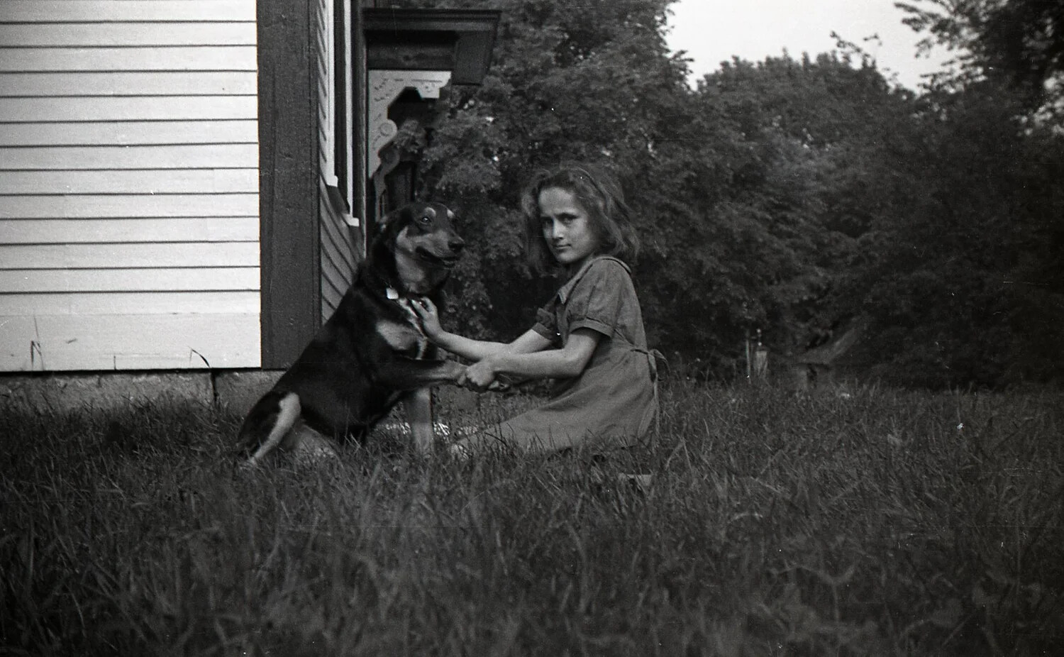 Girl Playing with Dog Beside Farmhouse, Mid-20th Century