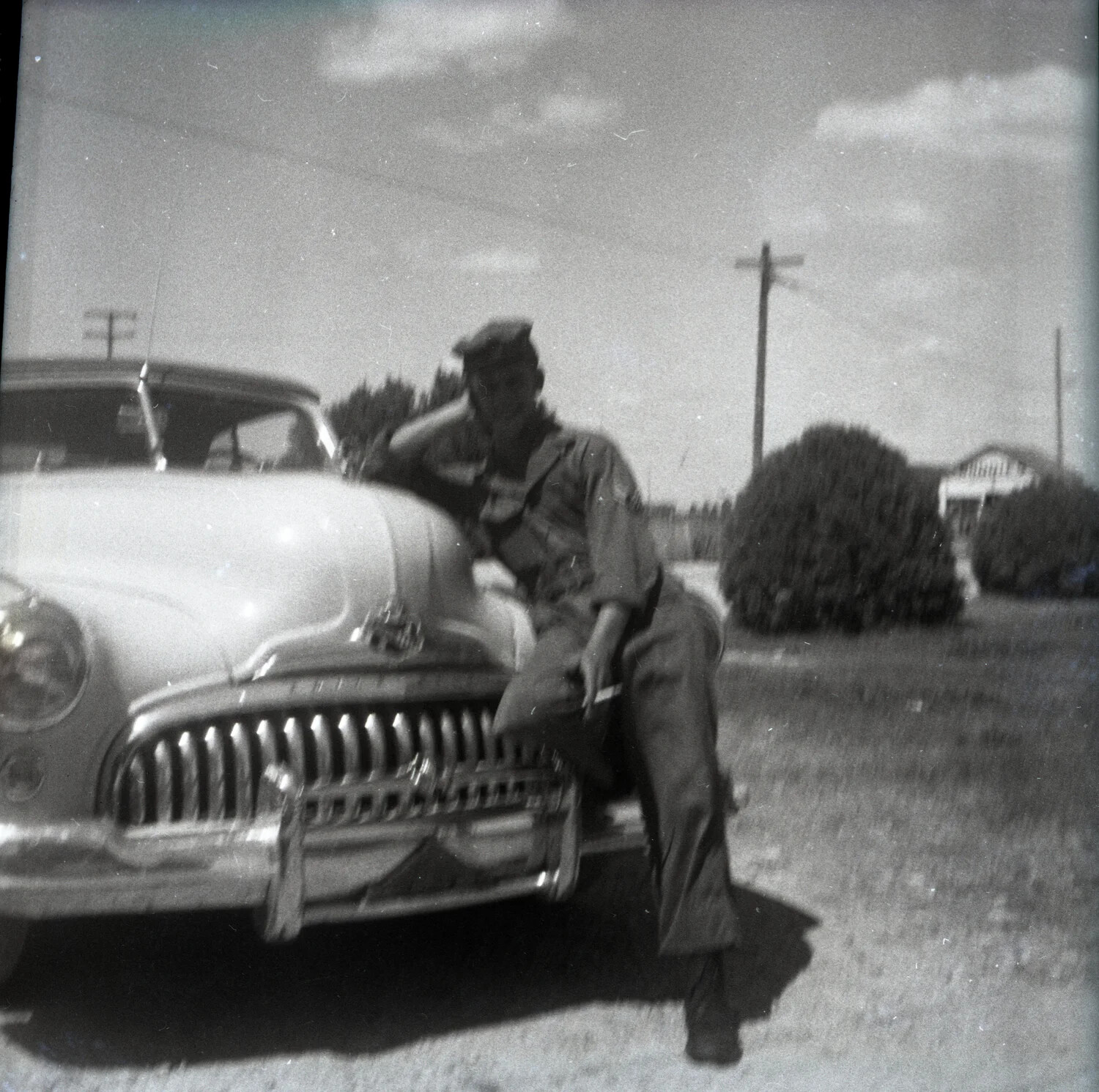 Serviceman Leaning on the Hood of a Buick Sedan, Smoking a Cigarette
