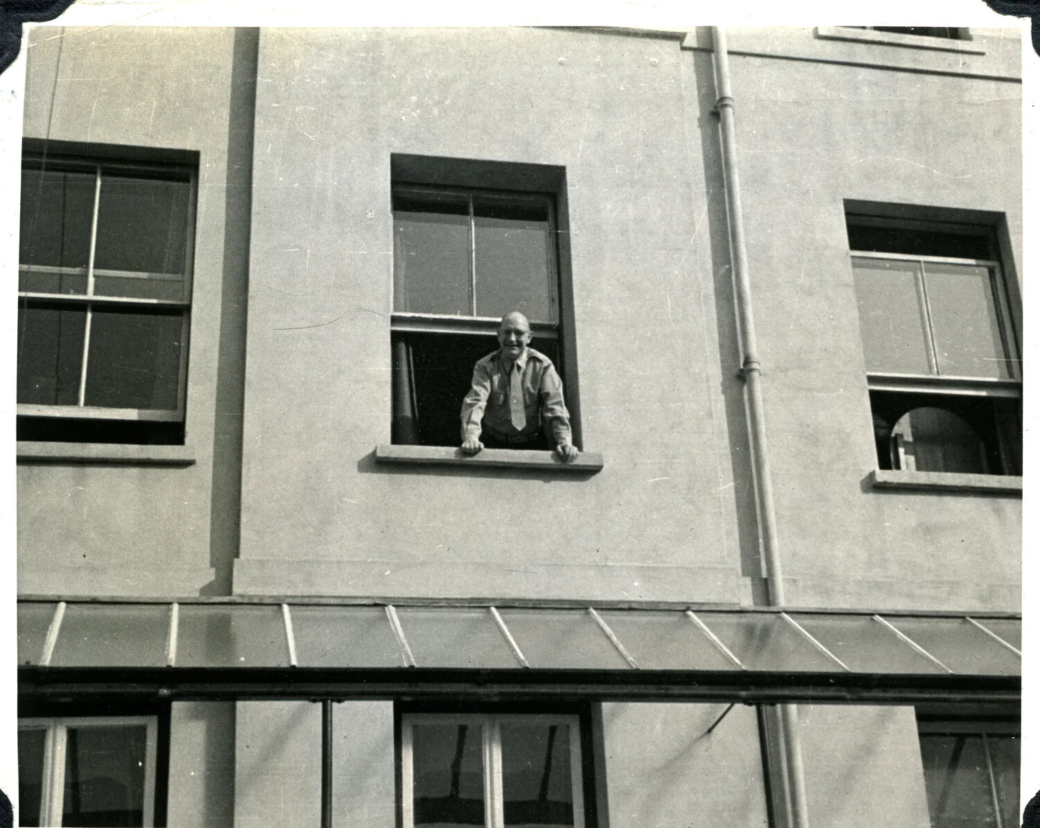 Serviceman Leaning from a Second-Story Window of an Administrative Building, Jervey Signal Corps Photo Album