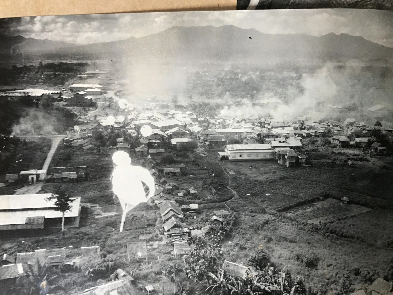 Close-Up Strike Photograph: Parafrag Bomb Deploying Over Village Rooftops, Luzon, 312th Bomb Group