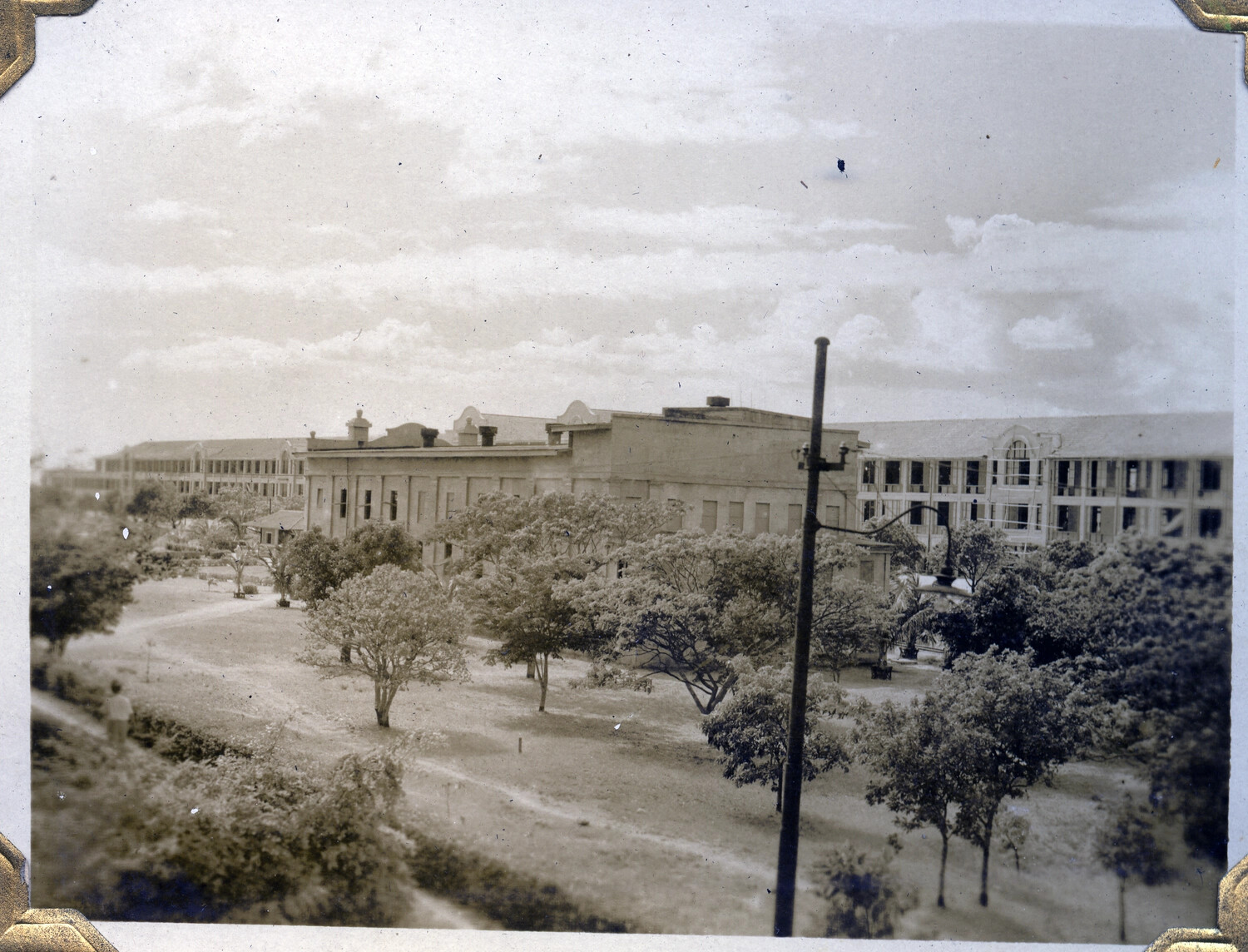 Tree-Lined Boulevard with Colonial-Era Institutional Buildings, Likely Manila, Philippines