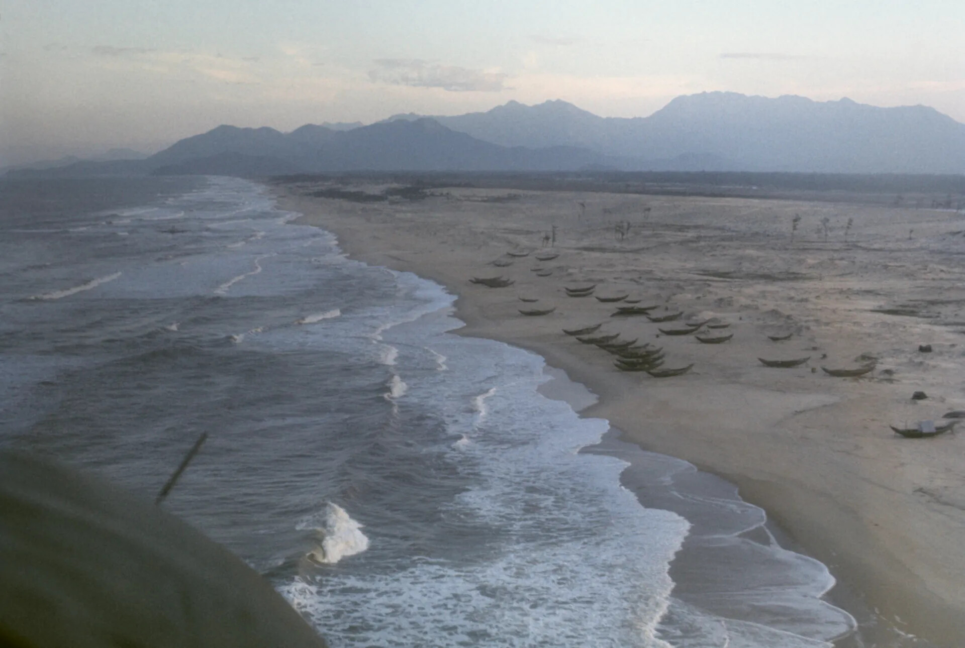 Oblique Aerial View of Vietnamese Coastline with Fishing Boats and Mountains at Dawn/Dusk