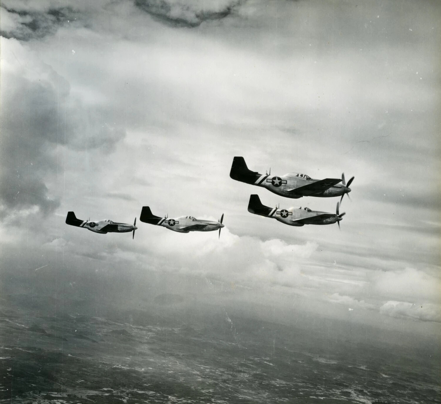 Formation of Four P-51 Mustang Fighters Above Cloud Layer (WWII-Era)