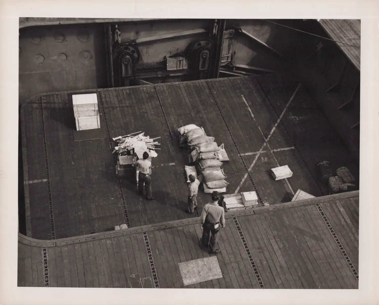 Overhead View of Sailors Handling Supplies on Aircraft Elevator, U.S. Navy Escort Carrier, World War II