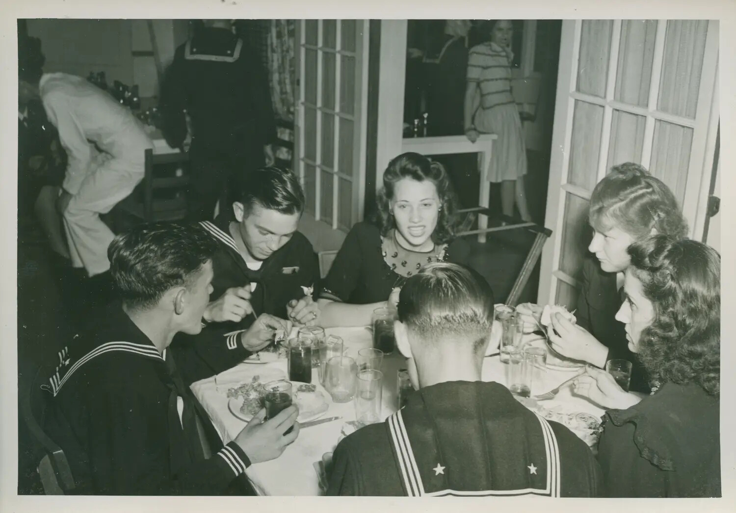 U.S. Navy Sailors and Civilian Guests at a Wartime Social Gathering, WWII Era