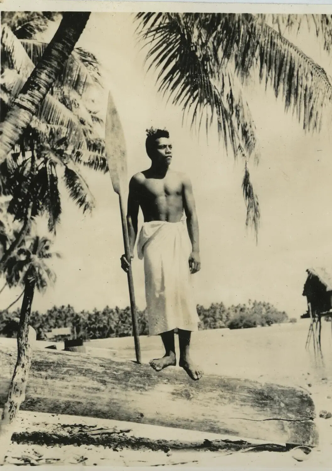 Pacific Islander Man with Canoe Paddle on Outrigger Hull, WWII-Era Snapshot, Pacific Theater