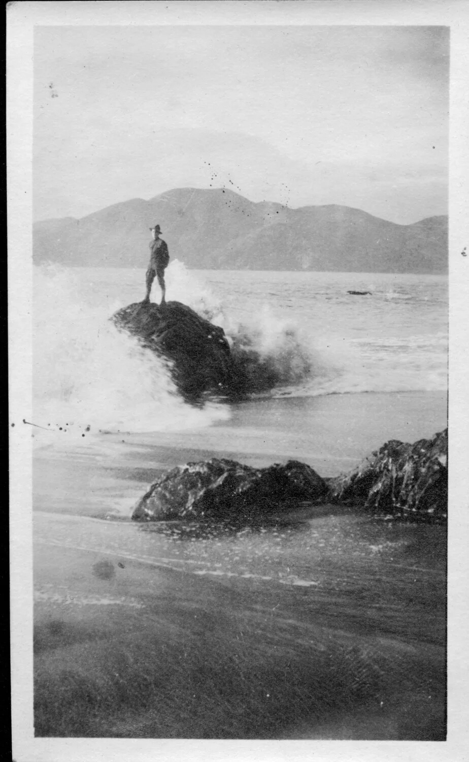Soldier Standing on Rock Amid Breaking Surf, San Francisco Coastline near the Presidio