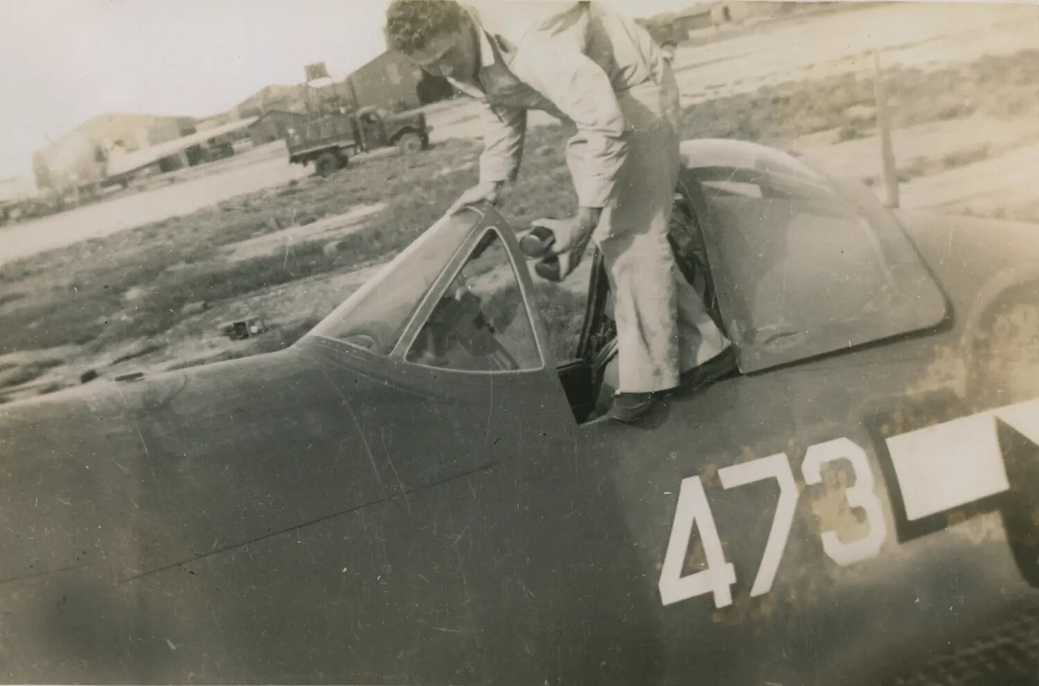 Airman Entering Cockpit of Single-Engine Trainer, Tail Number 473