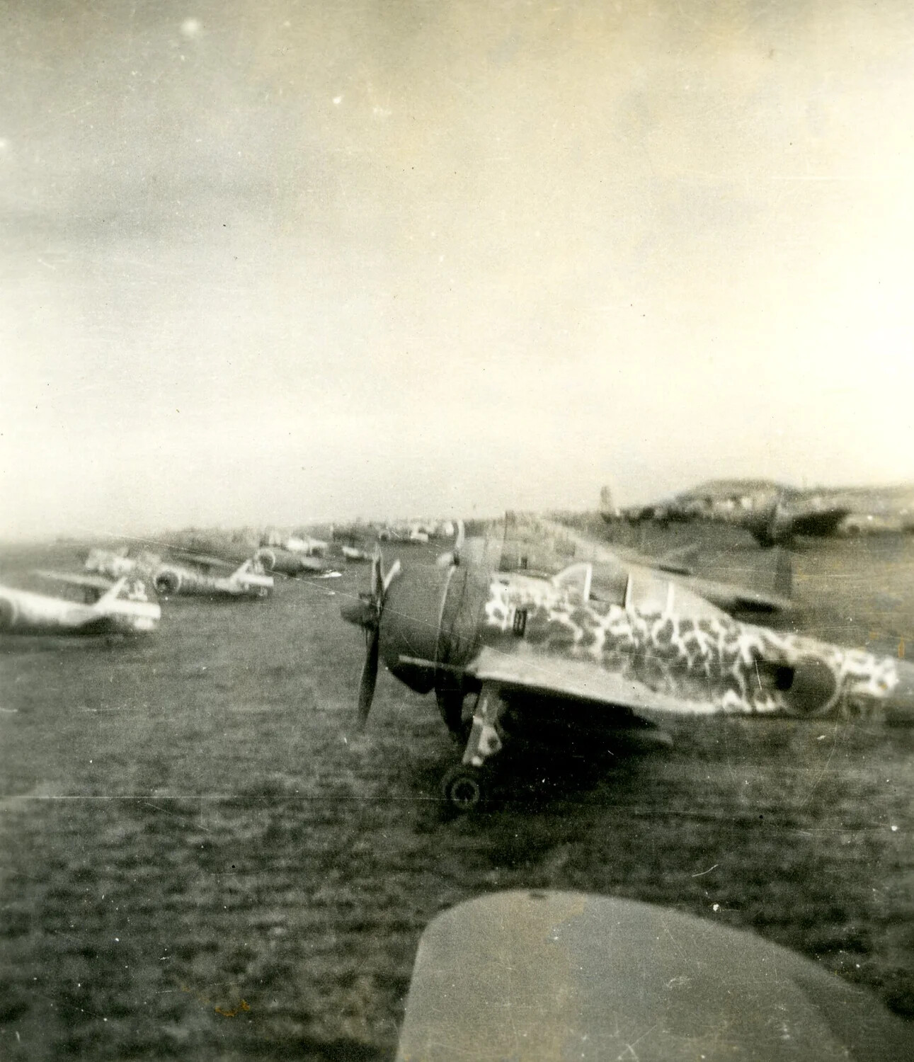 Row of Captured Japanese Aircraft with Mottled Camouflage on Airfield, Pacific Theater, WWII