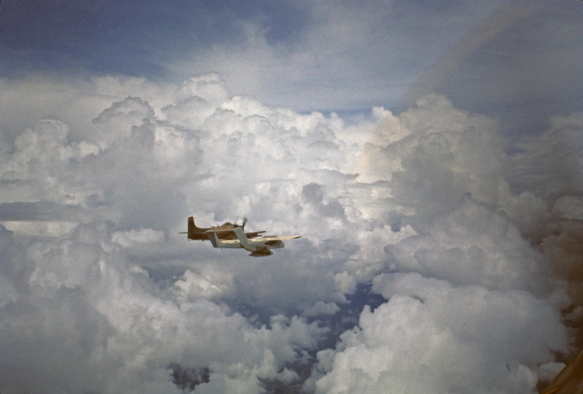 A-1 Skyraider in Flight Amid Towering Cumulus Clouds, Southeast Asia, Vietnam War