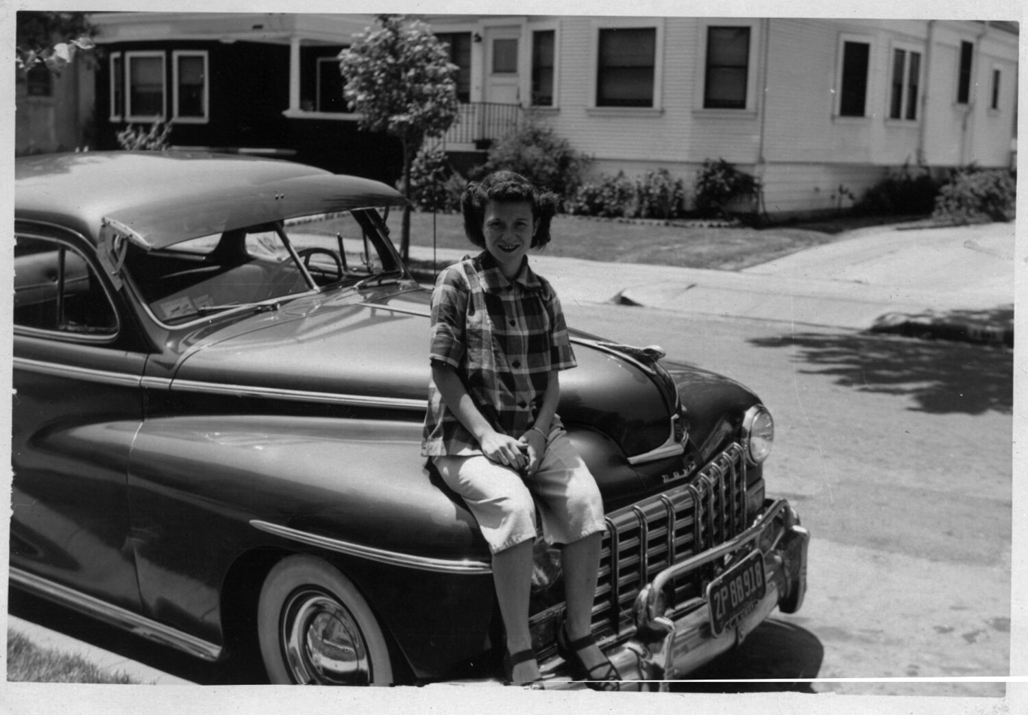 Woman Posed on Automobile in Residential Neighborhood, Bancroft Family Collection