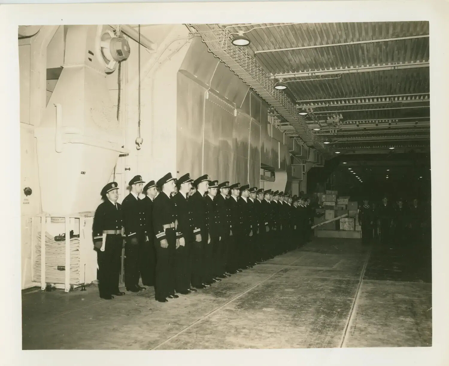 Naval Officers Standing in Formation in the Hangar Bay, USS Petrof Bay (CVE-80), WWII