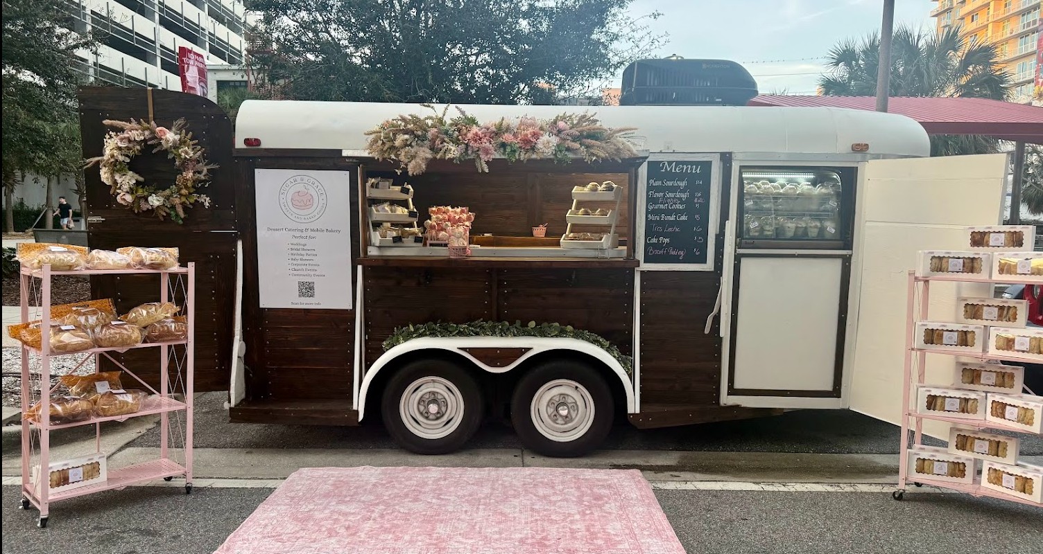 The Sugar and Grace dessert trailer at a market, styled with florals and signage.